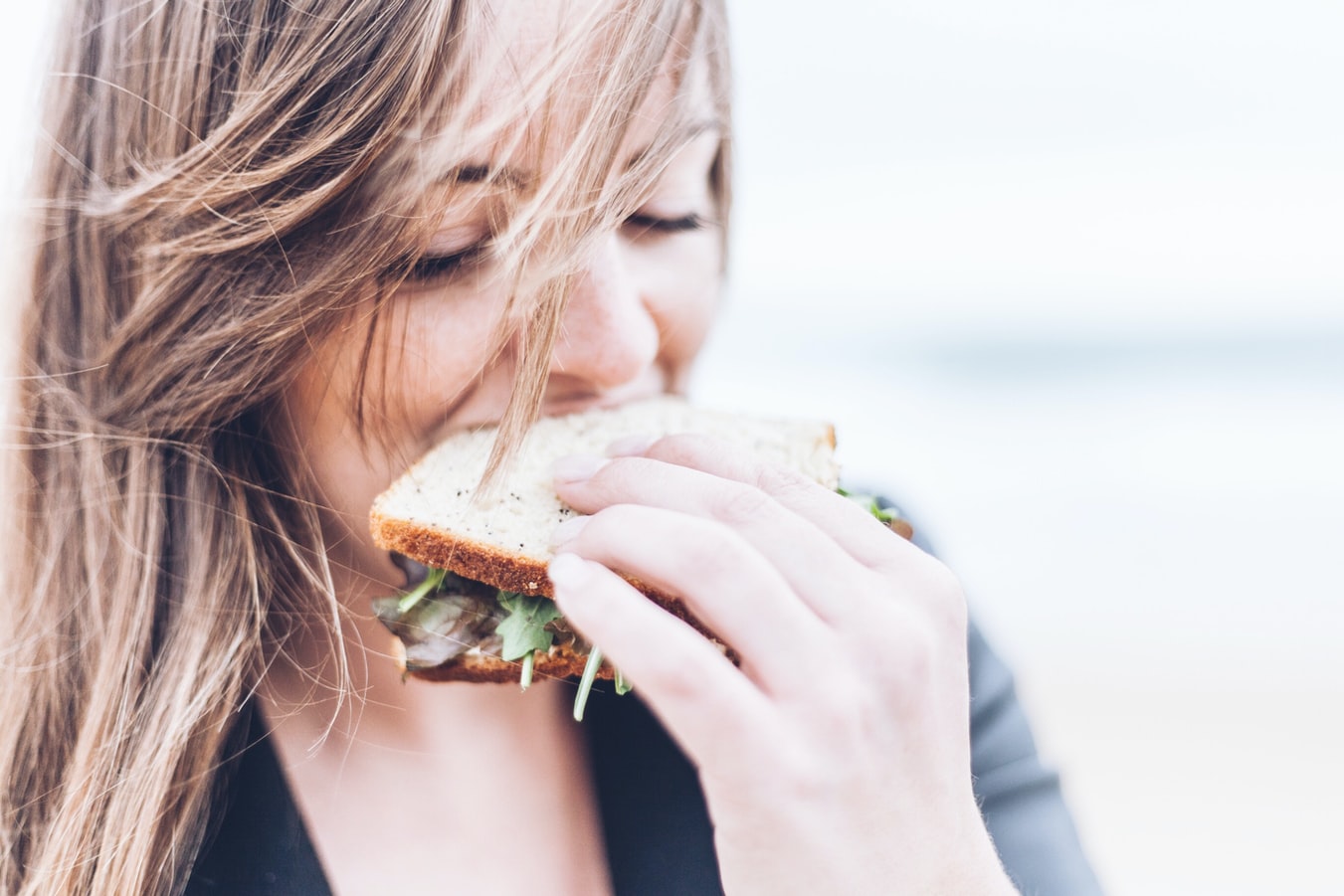 A woman eats a sandwich for lunch.