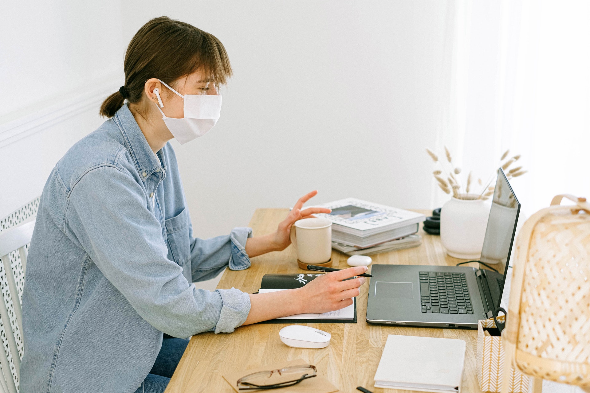woman with mask as desk on laptop