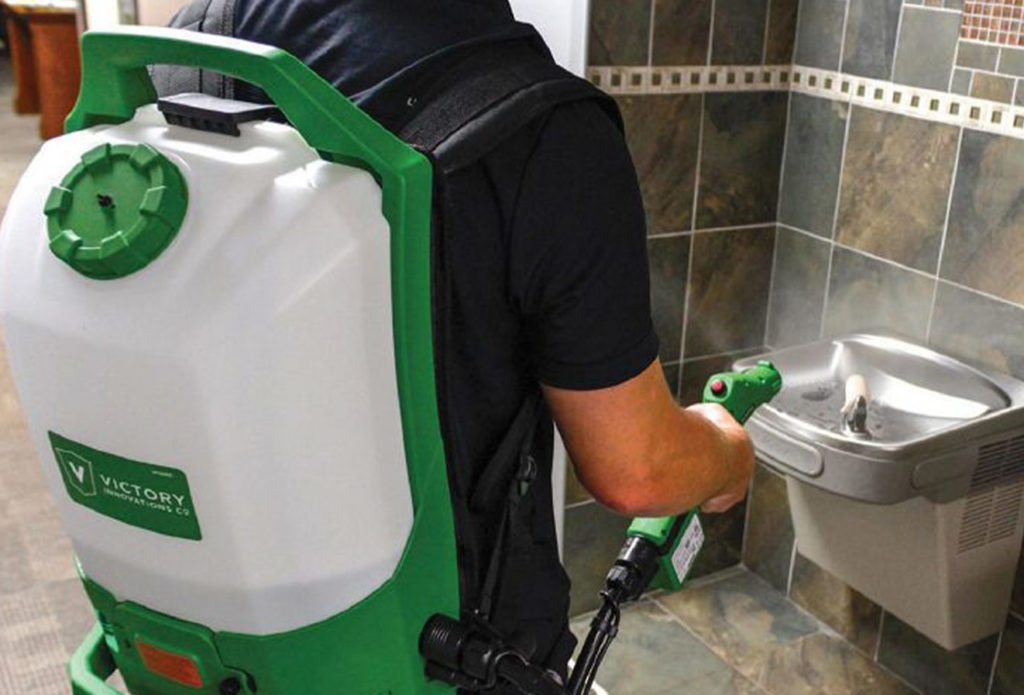 Person disinfecting area with Electrostatic Disinfection backpack.